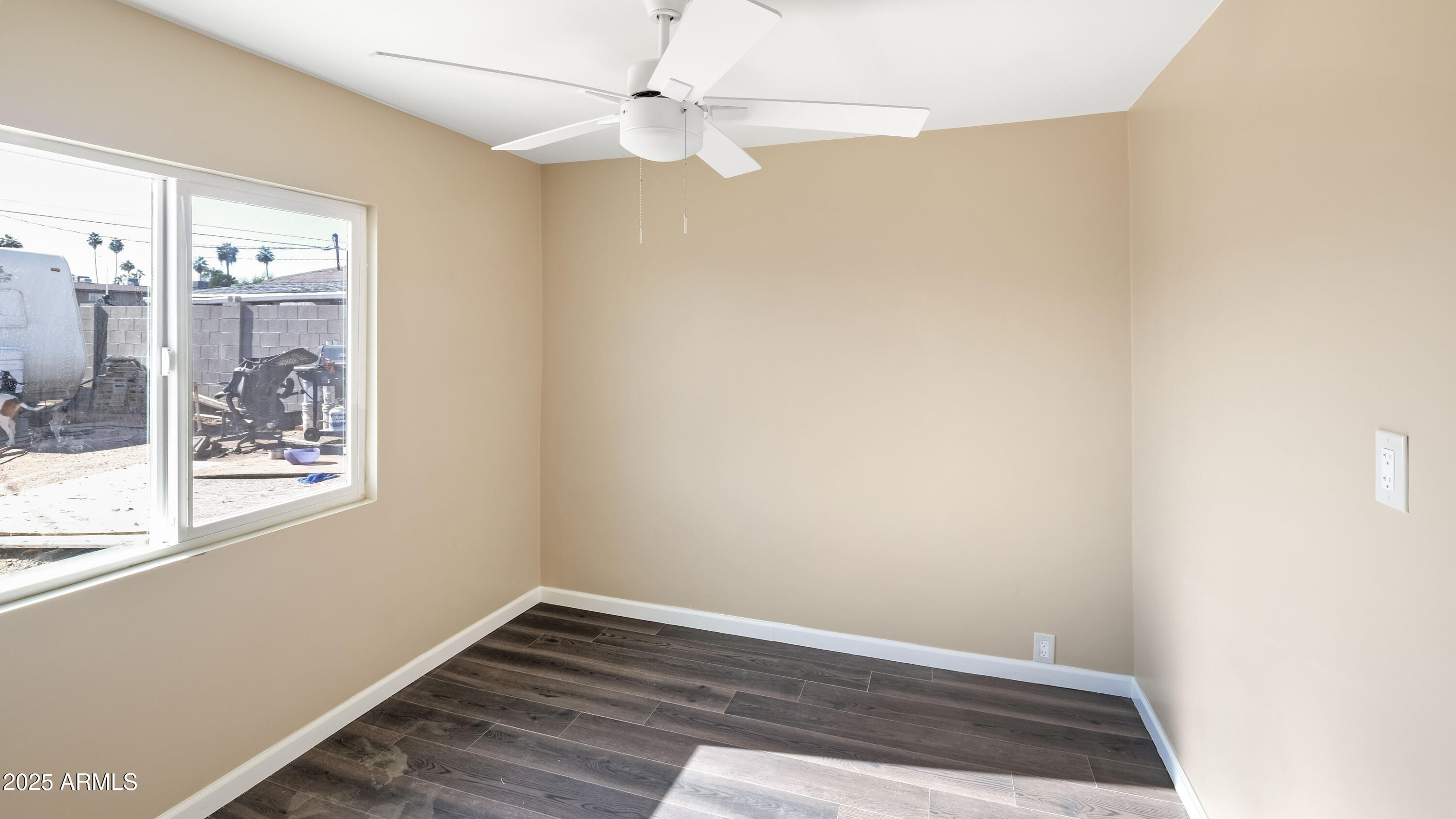 2333 West Coolidge Street Phoenix, AZ 85015 - Photo 7 of 9 an empty room with wooden floor fan and windows