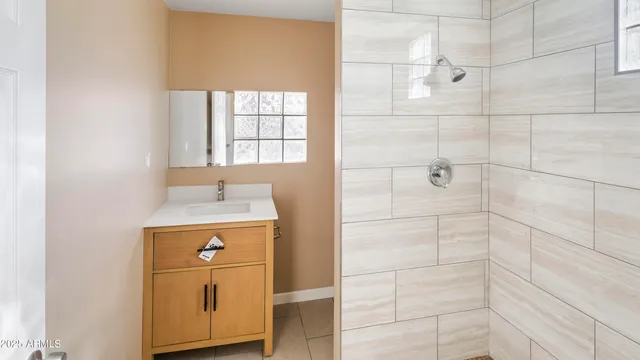 a bathroom with a granite countertop sink a vanity and shower