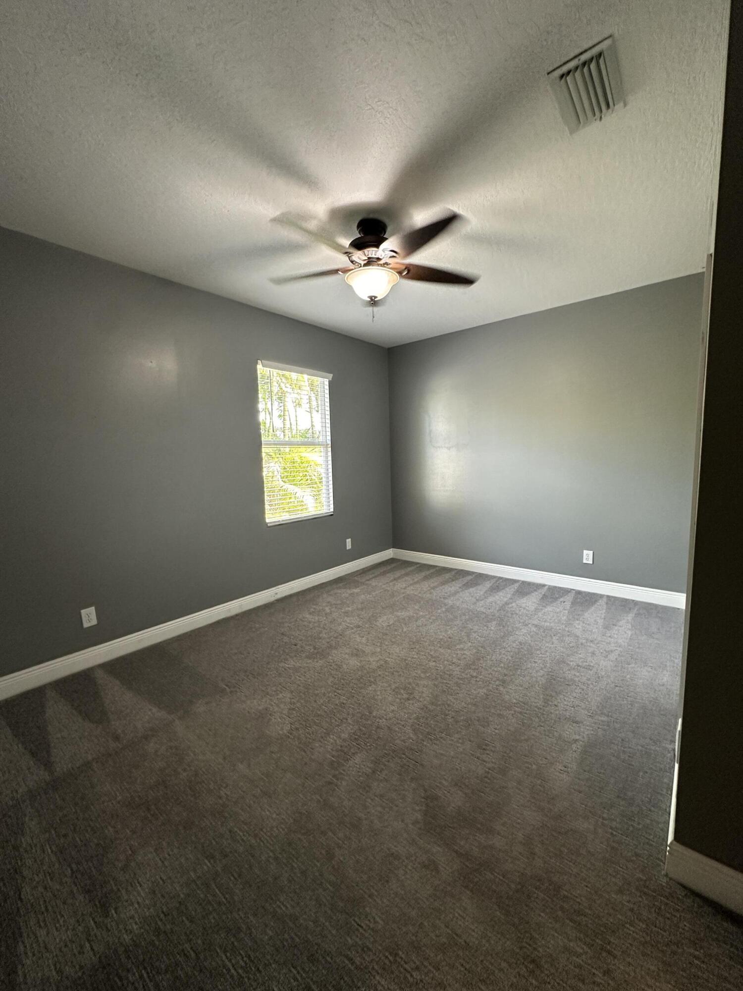 4010 Caparosa Circle Melbourne, FL 32940 - Photo 13 of 20 an empty room with windows and ceiling fan