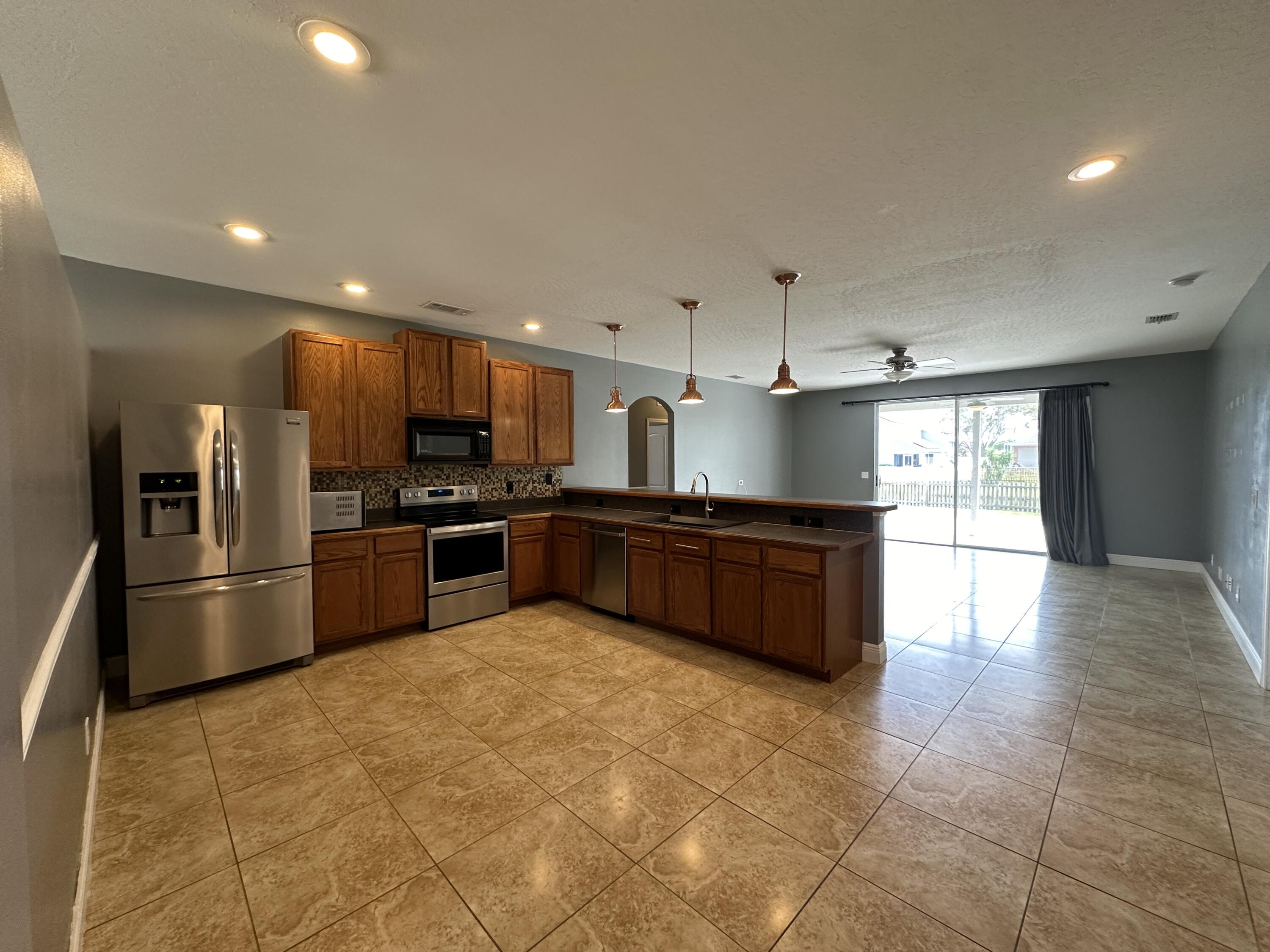 4010 Caparosa Circle Melbourne, FL 32940 - Photo 4 of 20 a large kitchen with a large counter top stainless steel appliances and cabinets