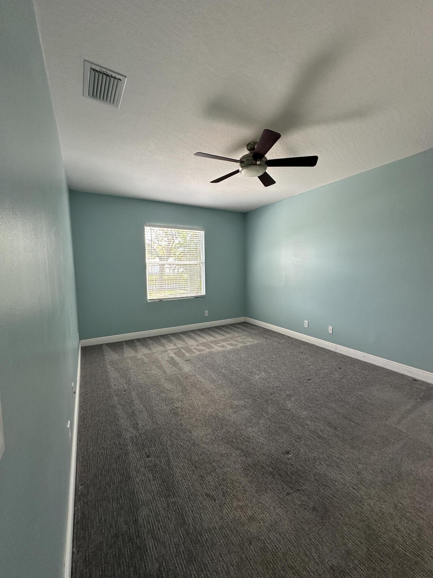 4010 Caparosa Circle Melbourne, FL 32940 - Photo 6 of 20 en empty room with windows and ceiling fan
