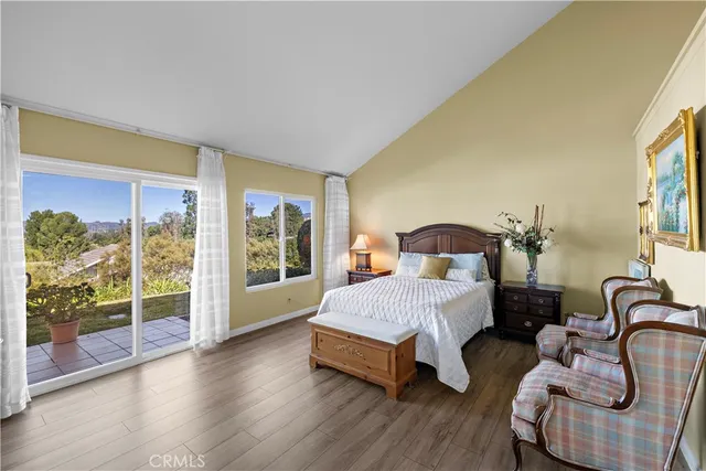 a spacious bedroom with a bed and wooden floor