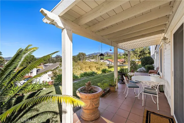 a view of a porch with chairs and potted plants