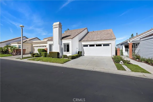 a front view of a house with a garden and yard