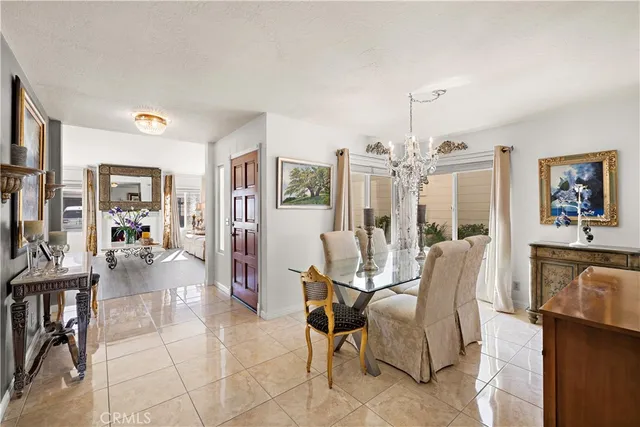 a living room with furniture a chandelier and a dining table