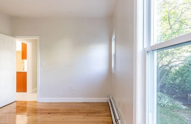 a view of room with window and wooden floor