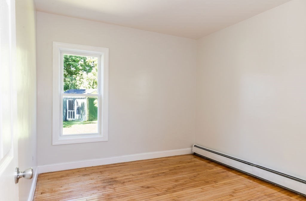 9 Denton Street, Unit 3 Brockton, MA 02301 - Photo 3 of 5 a view of an empty room with wooden floor and a window