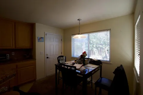 a view of a workspace with furniture and a window