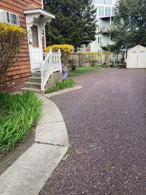 90 Prospect Street, Unit 2 Somerville, MA 02143 - Photo 25 of 27 a front view of a house with a yard and garage