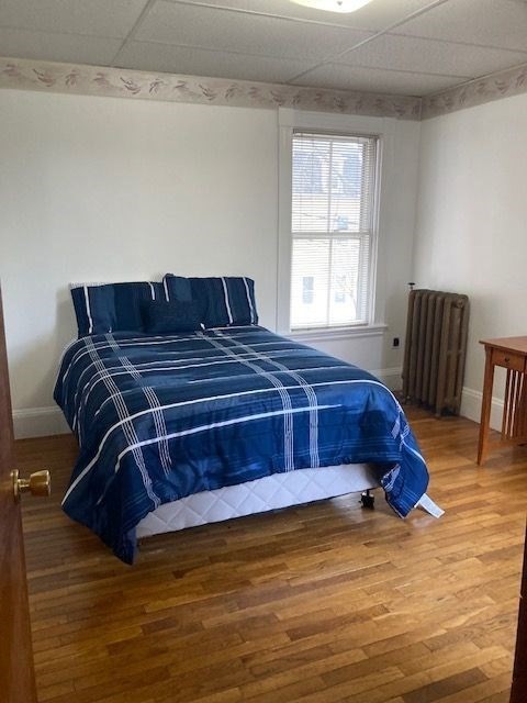90 Prospect Street, Unit 2 Somerville, MA 02143 - Photo 9 of 27 a bedroom with a bed and wooden floor
