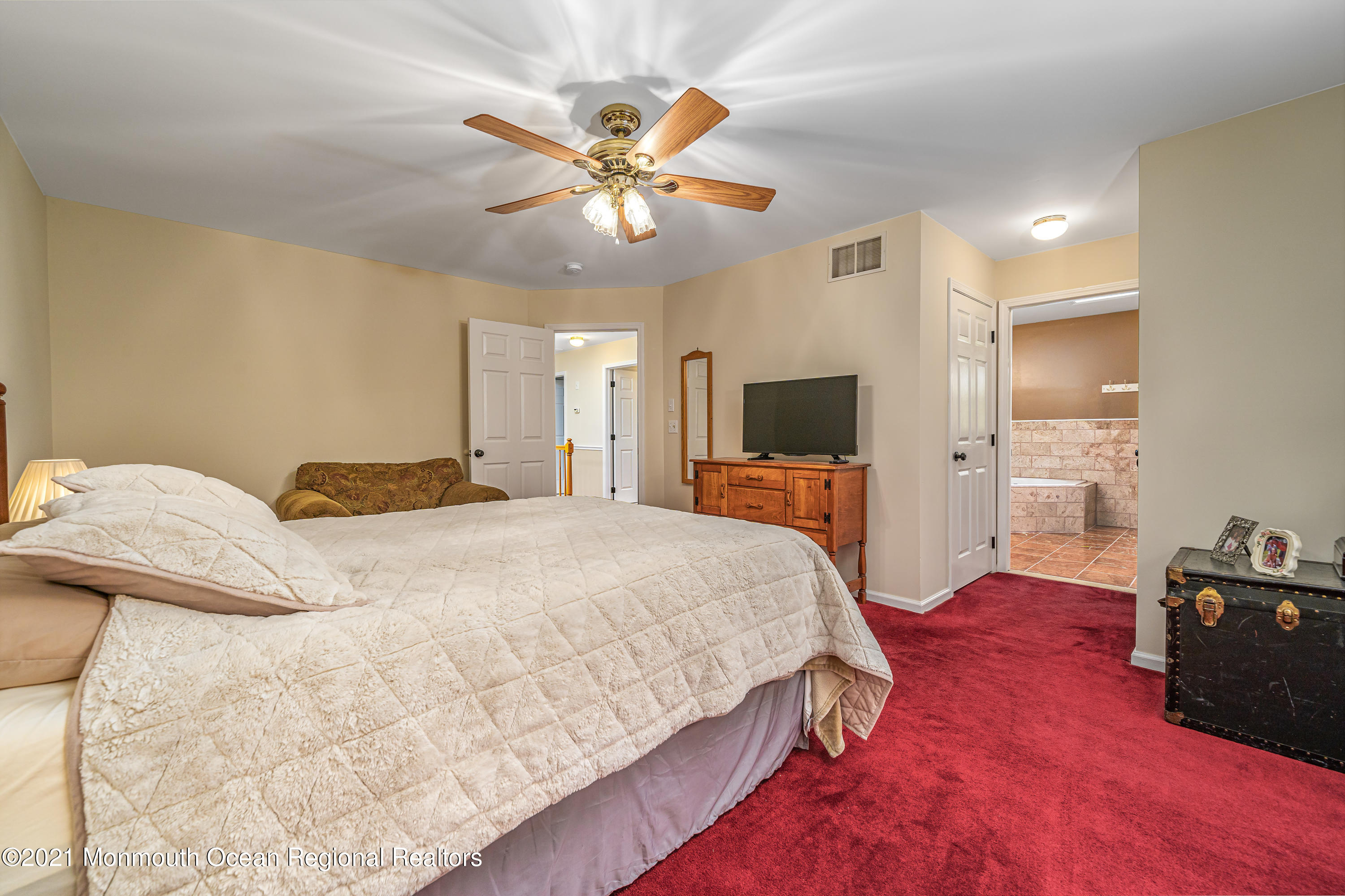 217 Topside Road Manahawkin, NJ 08050 - Photo 26 of 35 a spacious bedroom with a bed and a chandelier