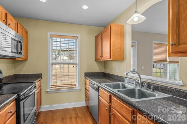a kitchen with stainless steel appliances granite countertop white cabinets and a stove top oven