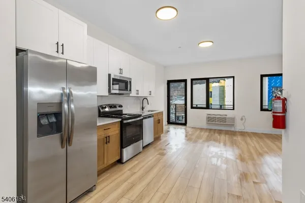 a kitchen with stainless steel appliances granite countertop a refrigerator a stove and a sink