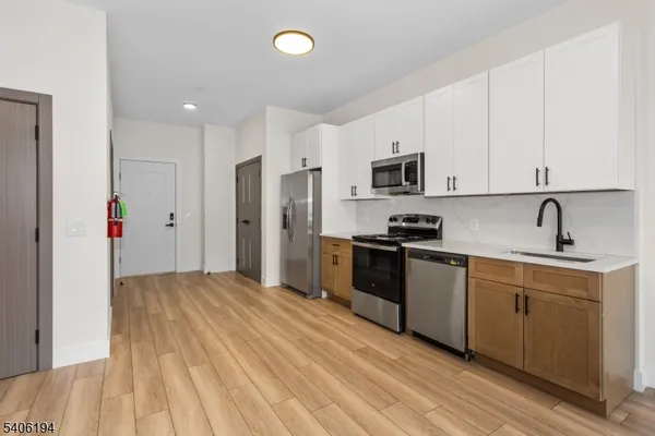 a kitchen with granite countertop a refrigerator stove top oven and sink