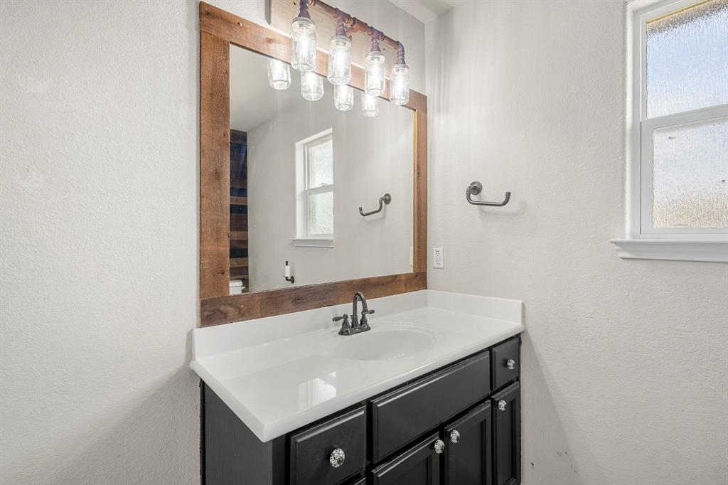 10620 Granada Drive Waco, TX 76708 - Photo 22 of 38 Vanity with black cabinetry, white countertop, and integrated sink