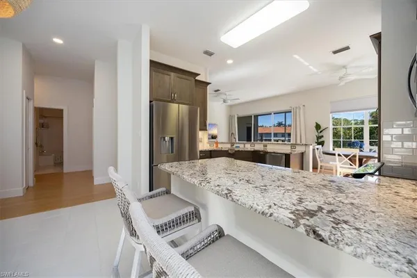 a living room with stainless steel appliances kitchen island granite countertop furniture and a kitchen view