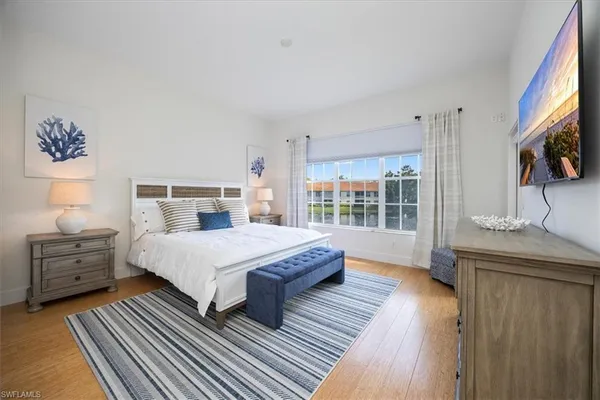 a spacious bedroom with a bed and wooden floor