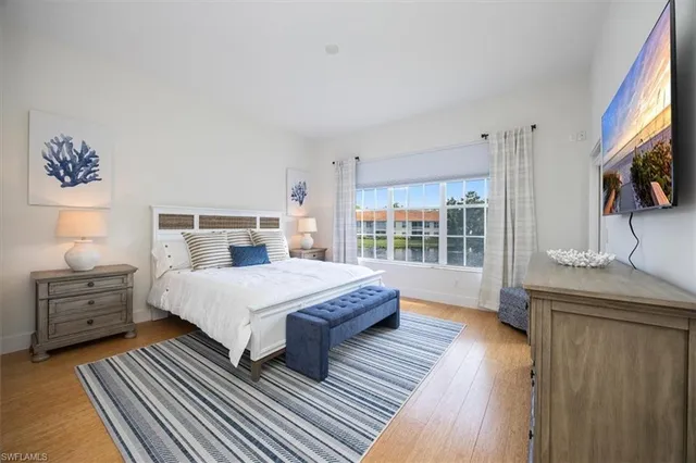 a spacious bedroom with a bed and wooden floor