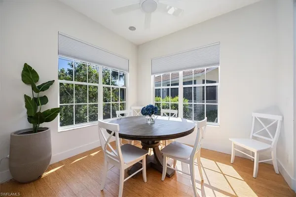 a dining room with furniture potted plants and wooden floor