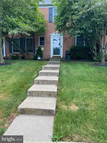 a front view of a house with a yard and trees
