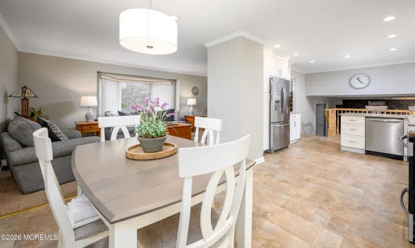 a kitchen with a dining table chairs and large window