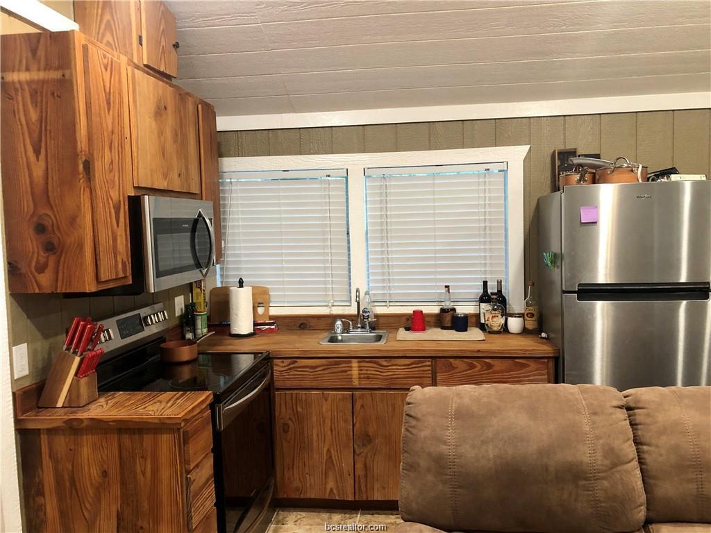 11351 Oak Lake Road Bryan, TX 77808 - Photo 3 of 20 a kitchen with a refrigerator a sink and a stove
