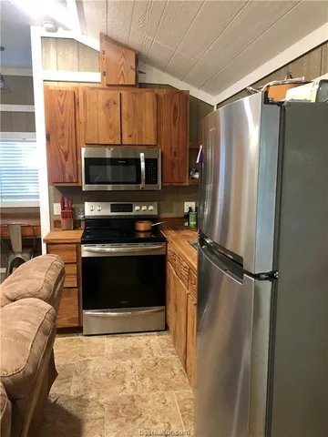 a kitchen with a refrigerator and a stove top oven