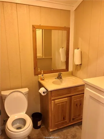a bathroom with a toilet a sink and mirror