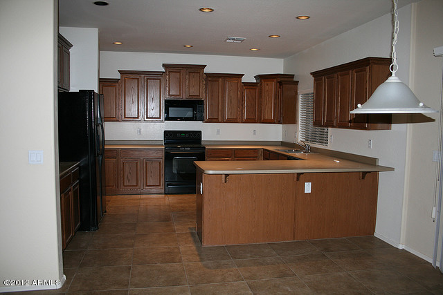 3044 South Martingale Road Gilbert, AZ 85295 - Photo 17 of 20 a kitchen with a sink a refrigerator and cabinets
