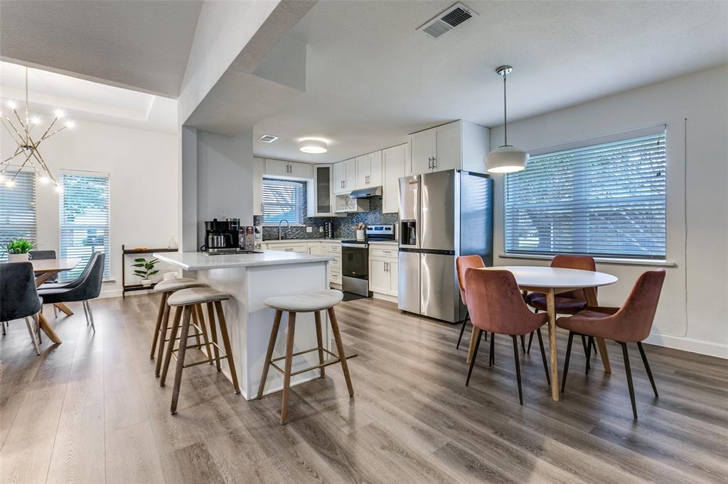 2901 Regal Road Plano, TX 75075 - Photo 23 of 23 a kitchen with stainless steel appliances a dining table chairs stove refrigerator and cabinets