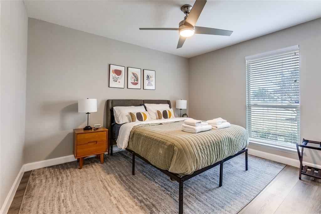 2901 Regal Road Plano, TX 75075 - Photo 18 of 23 a bedroom with a bed and a chandelier