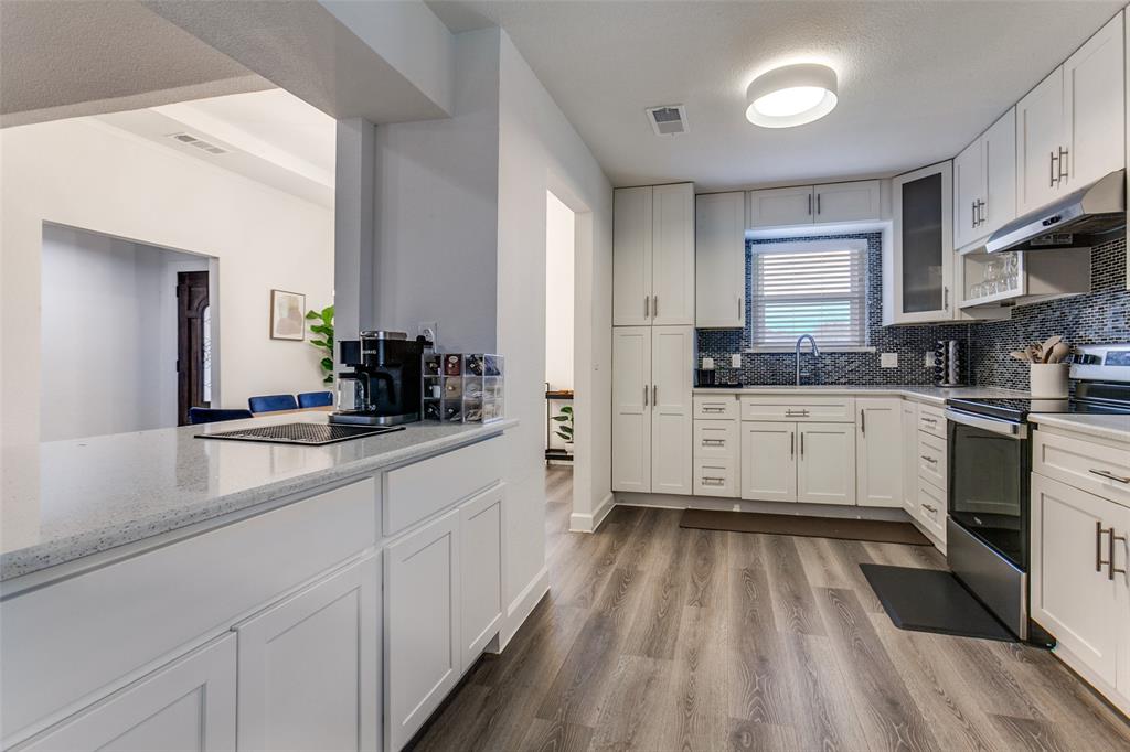 2901 Regal Road Plano, TX 75075 - Photo 8 of 23 a kitchen with a sink white cabinets and white appliances