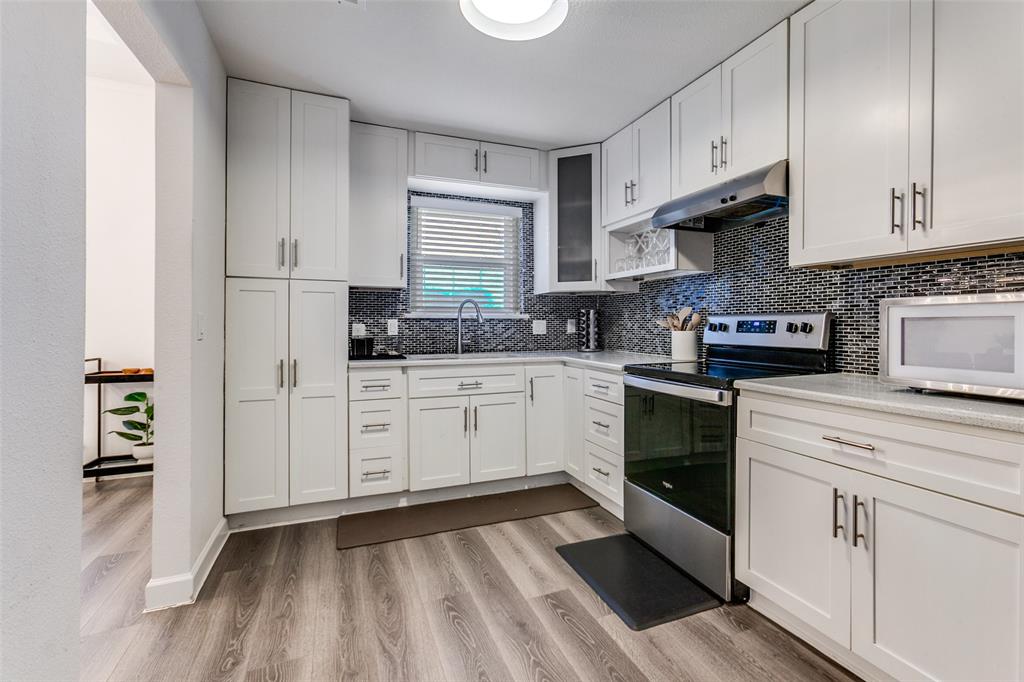 2901 Regal Road Plano, TX 75075 - Photo 9 of 23 a kitchen with granite countertop white cabinets and white appliances