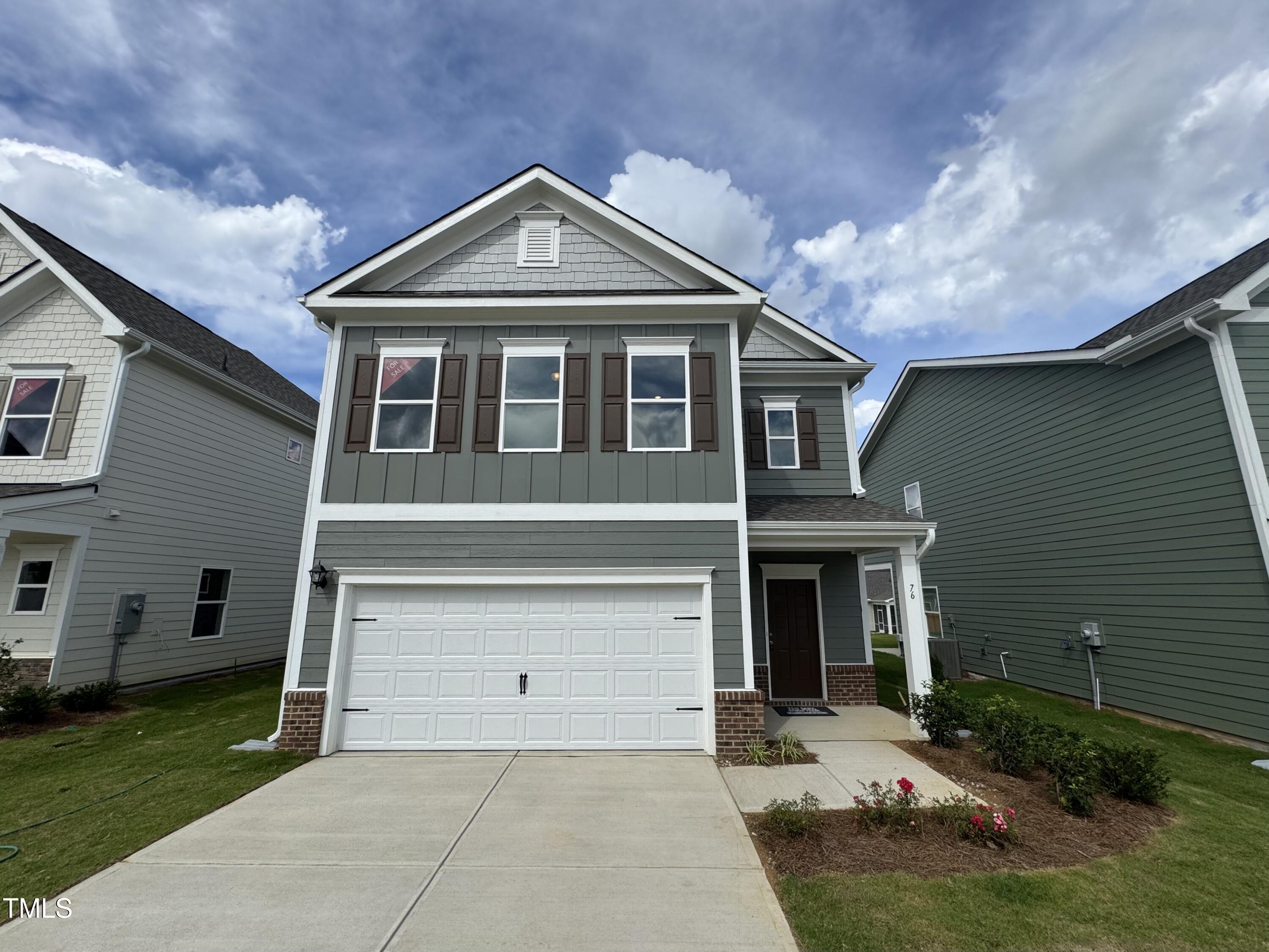 76 Commons Circle Clayton, NC 27520 - Photo 1 of 29 a front view of a house with a yard and garage