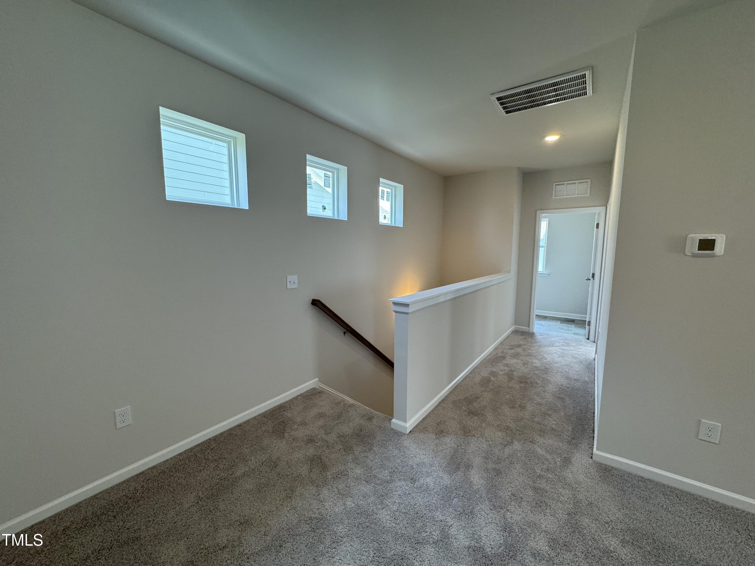 76 Commons Circle Clayton, NC 27520 - Photo 12 of 29 an empty room with windows and entrance