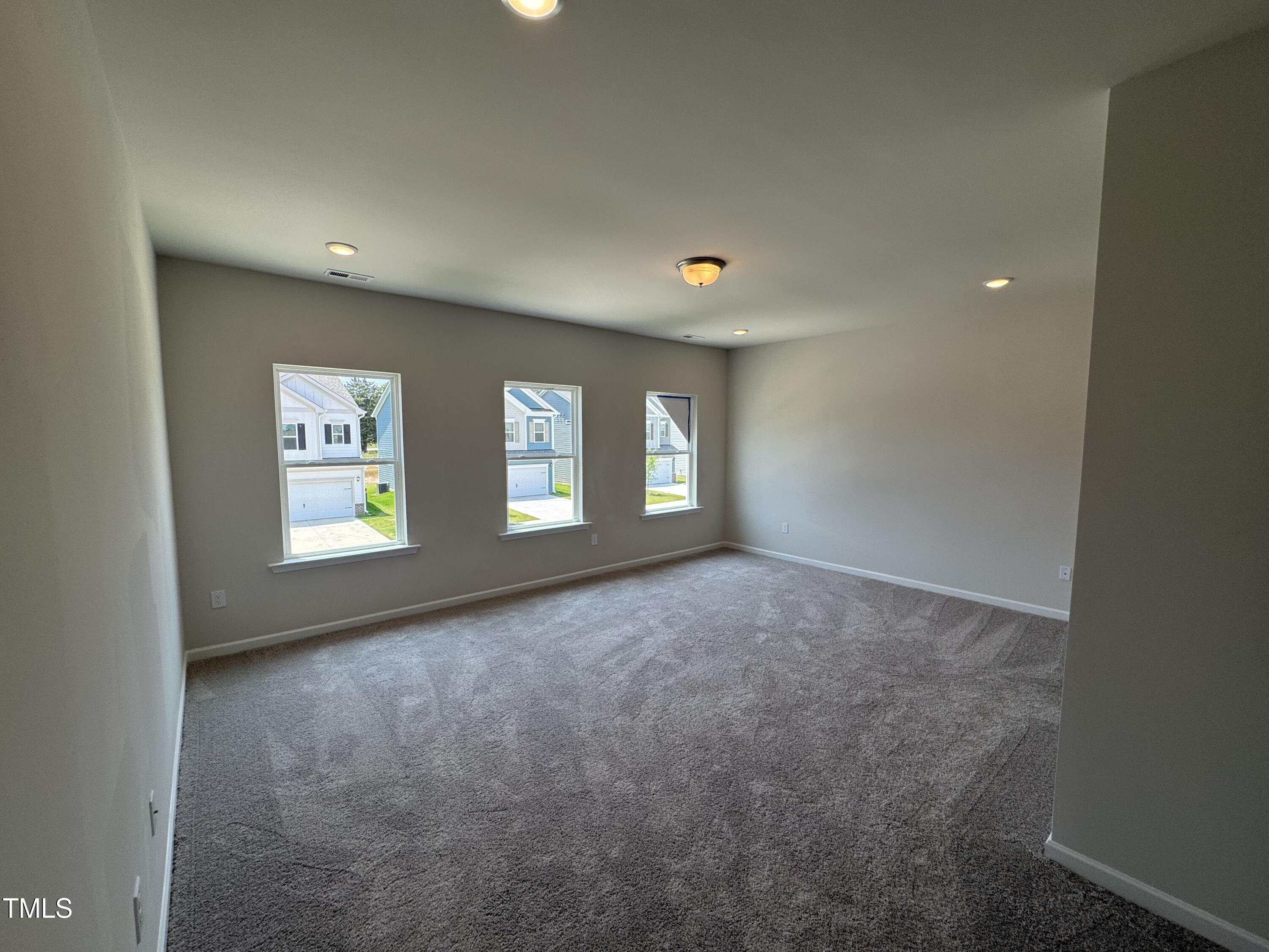 76 Commons Circle Clayton, NC 27520 - Photo 17 of 29 a view of an empty room with window and stairs