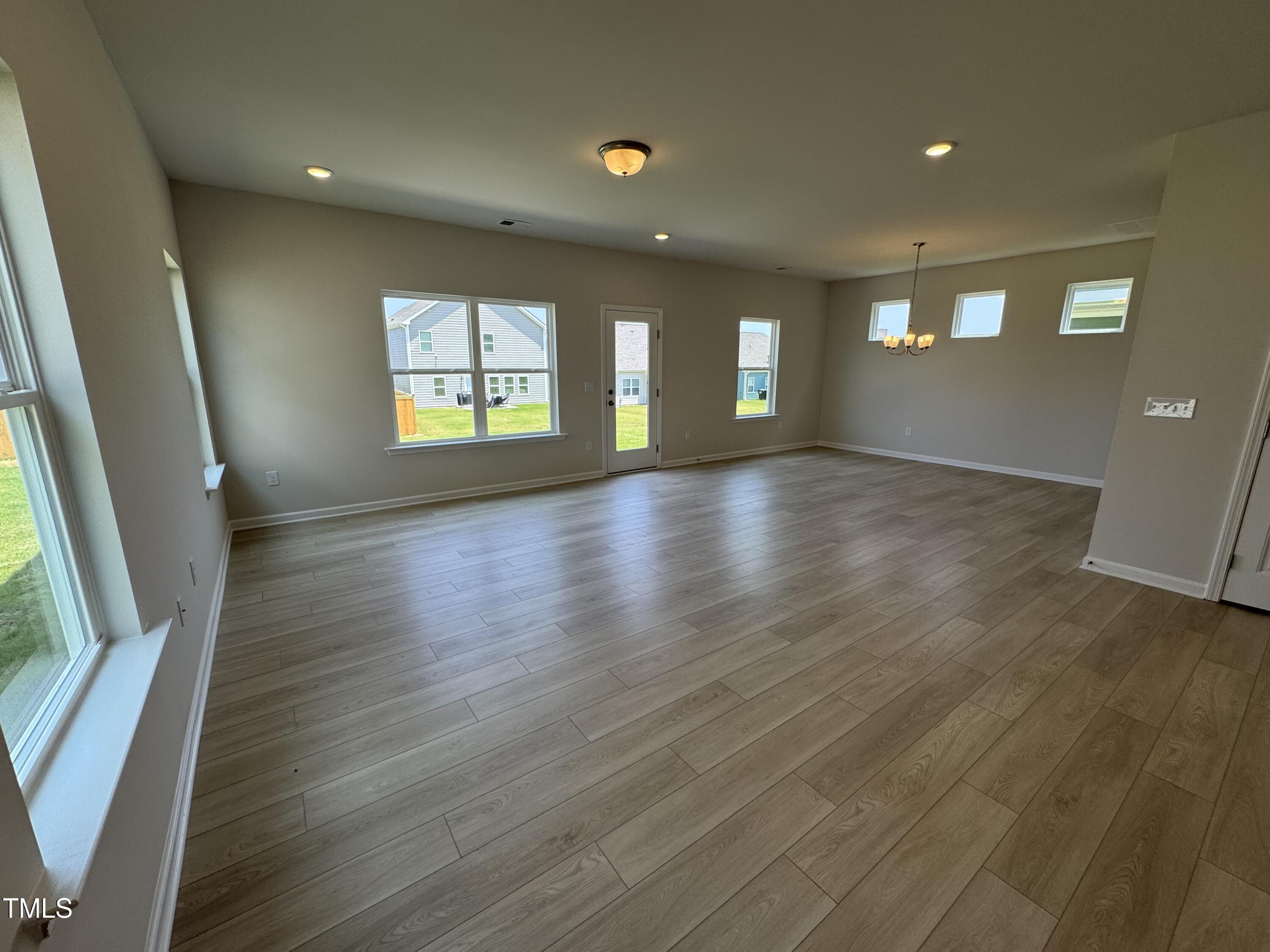 76 Commons Circle Clayton, NC 27520 - Photo 3 of 29 an empty room with wooden floor and windows