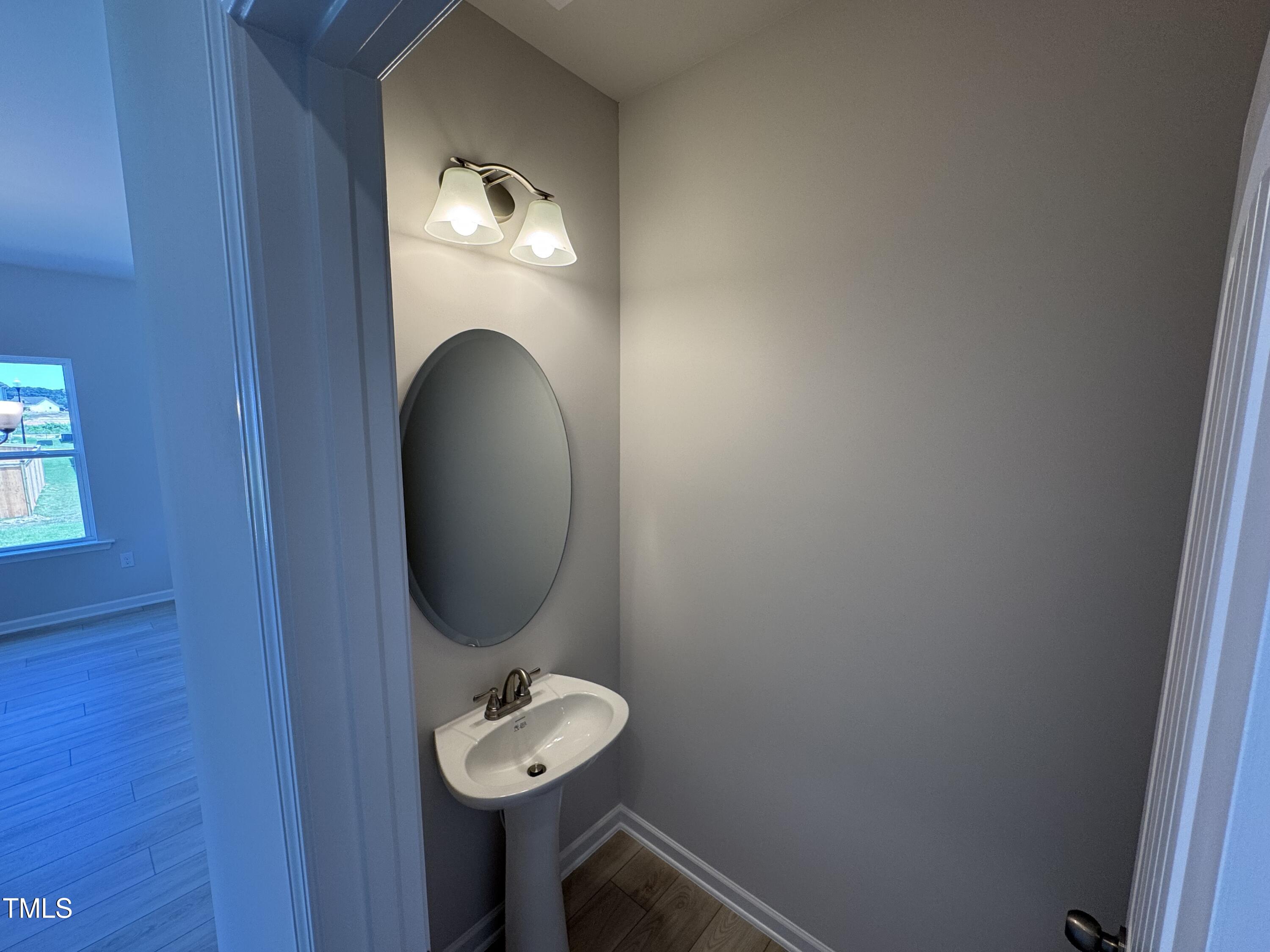 76 Commons Circle Clayton, NC 27520 - Photo 6 of 29 a bathroom with a sink and a mirror