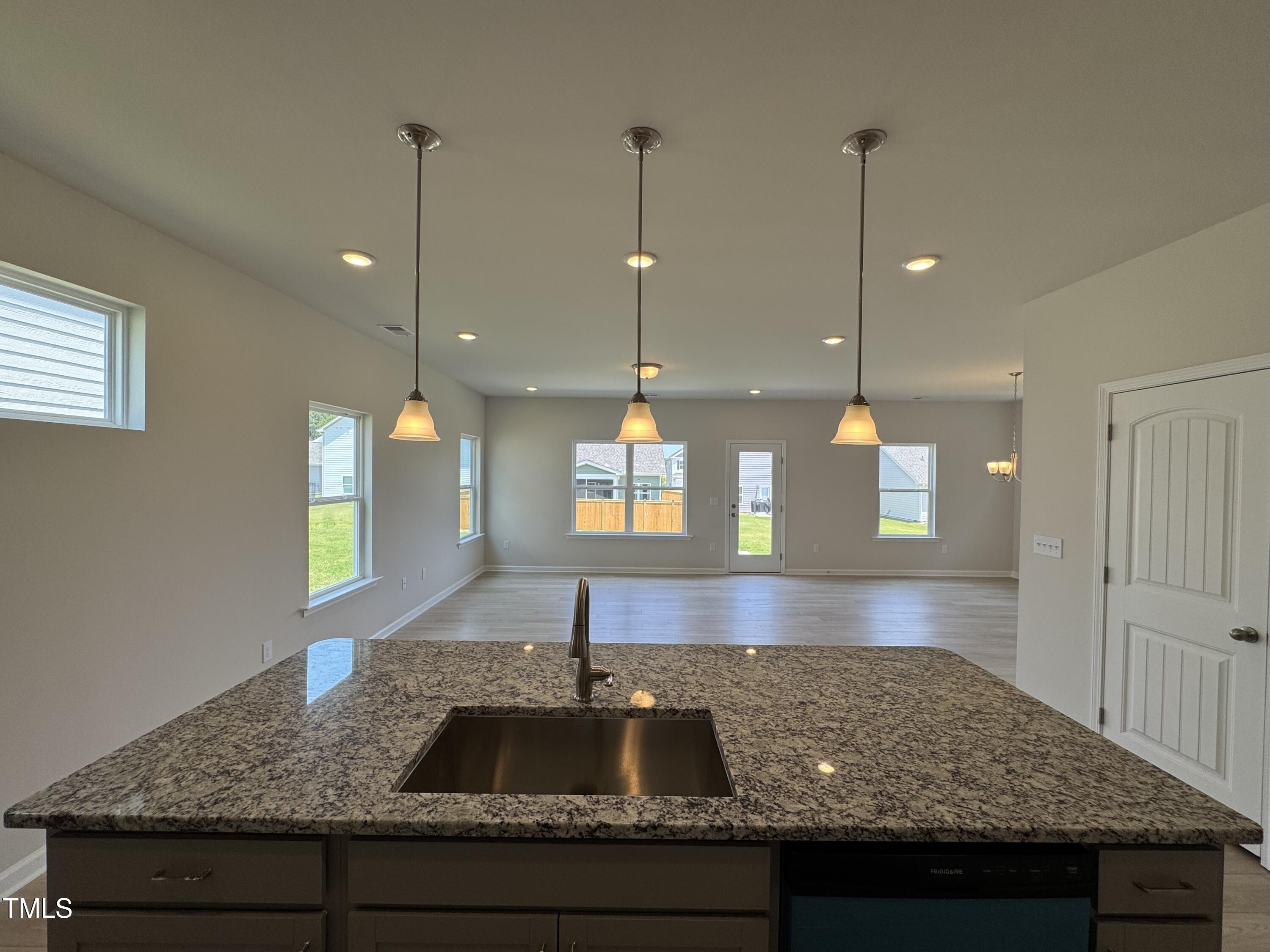 76 Commons Circle Clayton, NC 27520 - Photo 9 of 29 a kitchen with kitchen island granite countertop a sink a counter space and cabinets