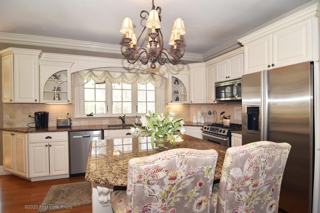 50 Cook Road Cumberland, RI 02864 - Photo 7 of 42 a kitchen with stainless steel appliances kitchen island granite countertop a refrigerator a stove a sink dishwasher and white cabinets with wooden floor