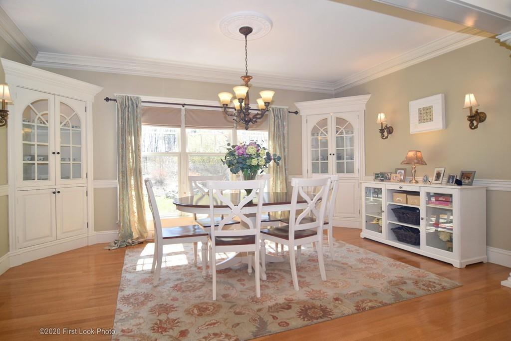 50 Cook Road Cumberland, RI 02864 - Photo 10 of 42 a dining room with wooden floor a chandelier a glass table and chairs