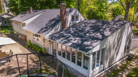 a view of house with a deck and a yard