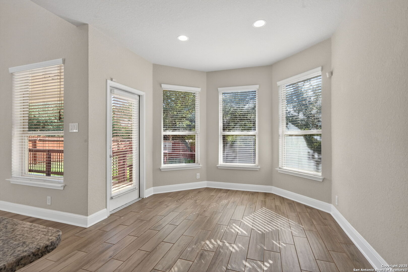 8326 Hydrangea Path Boerne, TX 78015 - Photo 12 of 39 an empty room with wooden floor and windows