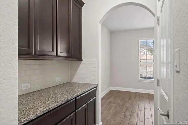 a kitchen with granite countertop a sink and wooden cabinets