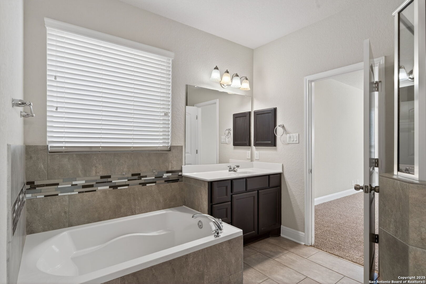 8326 Hydrangea Path Boerne, TX 78015 - Photo 21 of 39 a bathroom with a tub a sink and mirror