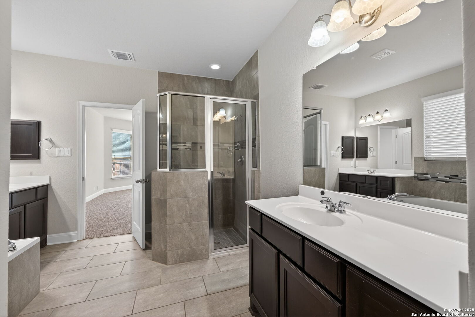 8326 Hydrangea Path Boerne, TX 78015 - Photo 23 of 39 a bathroom with a sink a faucet a mirror and a shower