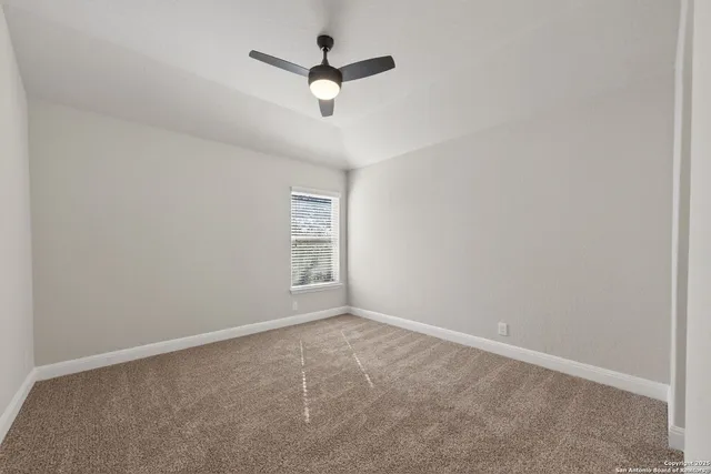an empty room with a window and a fan