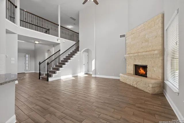 a view of a livingroom with wooden floor and a fireplace