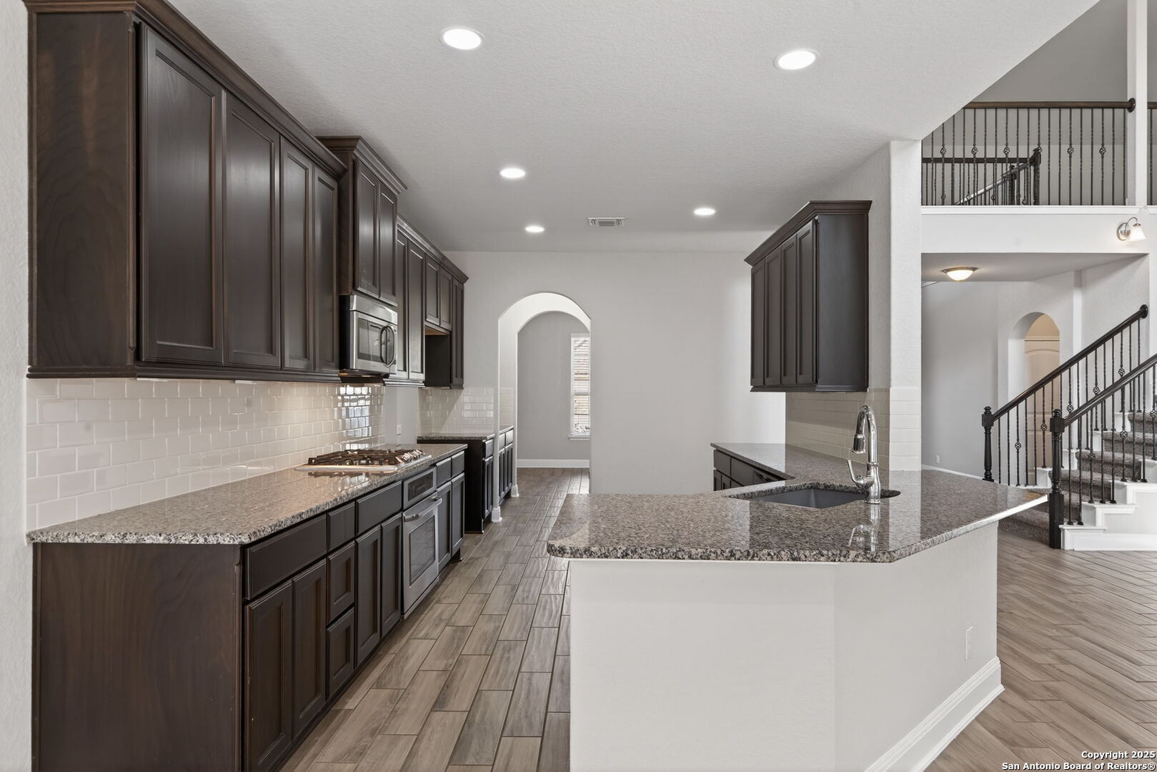 8326 Hydrangea Path Boerne, TX 78015 - Photo 9 of 39 a kitchen with stainless steel appliances granite countertop a sink a stove and a wooden floors