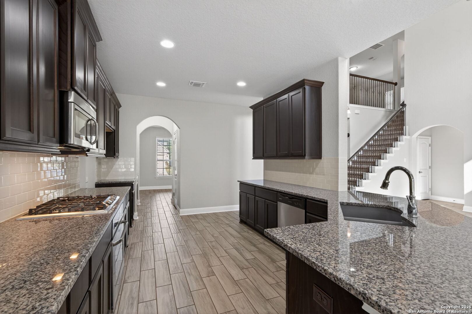 8326 Hydrangea Path Boerne, TX 78015 - Photo 10 of 39 a kitchen with stainless steel appliances granite countertop a sink a stove and a refrigerator